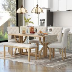 a dining room table with chairs and a bench