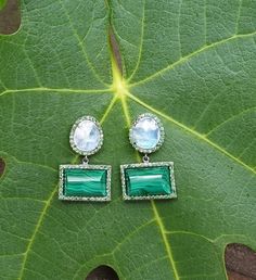 With their earthy elegance and vibrant combination of colors, these earrings also add a playful sophistication to any collection. The slightly domed malachite and faceted rainbow moonstone are framed by sparkling tsavorite stones. As casual or as dressy as you like, these earrings exude a playful, sophisticated style. Total length : 30mm malachite stone : 15mm x 12mm You might also like: https://www.etsy.com/listing/649858864/diamond-eearrings-crystal-quartz-and?ref=shop_home_active_22 Wear thes Green Multi-stone Drop Earrings, Green Drop Earrings With Gemstone Accents, Fusion Green Earrings With Natural Stones, Green Natural Stones Fusion Earrings, Green Fusion Earrings With Natural Stones, Green Natural Stone Fusion Earrings, Elegant Green Earrings With Natural Stones, Green Natural Stone Earrings For Wedding, Green Natural Stones Earrings For Wedding