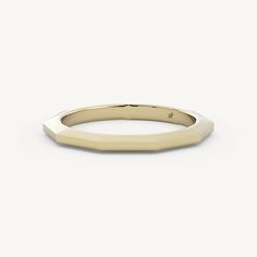 a gold wedding ring with a thin band on the top and an irregular shaped edge