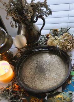 a metal tray sitting on top of a table next to candles