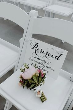 a white chair with a sign and flowers on it