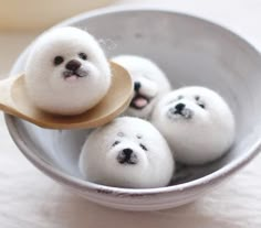 small white balls with faces are in a bowl