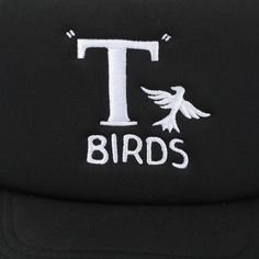 Rock a classic look with this black Grease trucker hat featuring the iconic T-Birds logo. With gray mesh on the sides and back, this hat combines style and comfort seamlessly. Made from durable polyester, it comes with an adjustable snapback closure, ensuring a perfect fit. Hand wash it in cold water and lay it flat to dry for easy care. This officially licensed Grease accessory brings authenticity and style to your wardrobe. Elevate your fashion game with this timeless T-Birds trucker hat. Black Trucker Hat With Letter Print For Outdoor, Black 5-panel Trucker Hat With Embroidered Logo, Black Trucker Hat With Letter Print And Flat Bill, Black Embroidered Logo 5-panel Trucker Hat, Black Hip Hop Trucker Hat With Embroidered Logo, Black 5-panel Trucker Hat With Letter Print, Black 5-panel Snapback Hat With Letter Print, Black Trucker Hat With Letter Print And Curved Brim, Black Letter Print Snapback Trucker Hat