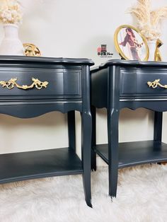 two dark blue nightstands with gold handles on white furnishing next to each other