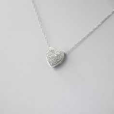 Single cut diamonds are pave set into this 14k white gold heart pendant. A Singapore white gold chain is the perfect addition to complete this necklace. Metal: 14K White Gold Necklace Length: 16 Inches Pendant Length x Width: 3/8 x 3/8 Inches Diamonds: .17 CTW, SI1 E-F For a greater selection of jewelry please visit our website at www.BlackMarketLLC.com If you have any questions about this product or if we can help you with any of our other products please contact us through Etsy or our website White Gold Heart-shaped Necklace With Pave Setting, White Gold Heart Cut Necklace With Pave Setting, Diamond White Sterling Silver Heart Necklace, Silver Heart-shaped Diamond Necklace With Pave Setting, Sterling Silver Heart Necklace With Diamond Accents For Wedding, White Gold Heart Cut Diamond Necklace With Pave Setting, Valentine's Day White Diamond Necklace With Single Cut Diamonds, White Heart Pendant Necklace With Pave Setting, Dainty Silver Diamond Heart Necklace