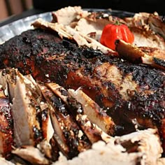 barbecued meat with tomatoes and onions on a metal plate, ready to be eaten