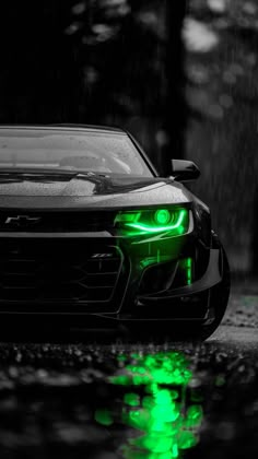 a car with green lights parked in the rain