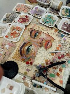 a table topped with plates covered in mosaics and other crafting supplies on top of it