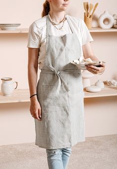 a woman in an apron is holding a plate