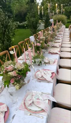 a long table is set with pink and white place settings