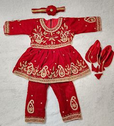 This is a 100% brand new never used red velvet pasni dress with excellent embroidery for new born baby girls for their special rice feeding ceremony that marks their 6 month age. The cloth is hand selected boutique piece designed by Nepali tailor especially for pasni or rice feeding ceremony. This set includes a dress,headband, socks and pant.  Washing instruction: dry clean only Free shipping Allover USA. Worldwide shipping available, shipping time varies as per country normally 10-15 days. Festive Red Velvet Traditional Wear, Red Velvet Sets For Eid, Festive Red Velvet Choli, Festive Embroidered Dress For Puja, Anarkali Embroidered Dress For Puja, Festive Sets With Handwork For Celebration, Red Velvet Traditional Wear For Festive Occasions, Traditional Red Velvet Set, Festive Red Velvet Dress