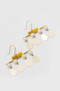 Porcelain & Brass Earrings - Crafted to captivate, Mary Hambys Make Your Move Earrings are more than mere accessories; theyre a reminder to stay daring and keep moving forward. Each earring features a hand-glazed porcelain cylinder perched atop a glimmering brass bar, all the while porcelain spheres and droplets of brass dance below. Lightweight yet substantial, they hang from gold-filled ear wires. Brass Bar, Contemporary Earrings, Keep Moving Forward, Earring Crafts, Keep Moving, Brass Earrings, Leather Earrings, Moving Forward, Ear Wires