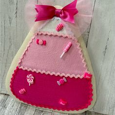 a pink and white felt hanging decoration with candy on it