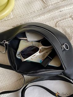 a black purse with sunglasses and other items in it