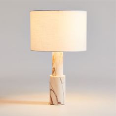 a marble lamp with a white shade on it