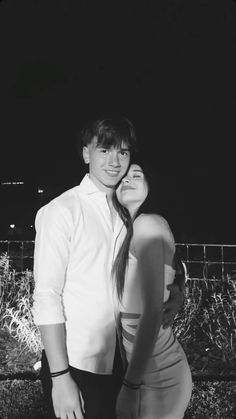 a man and woman are posing for a black and white photo