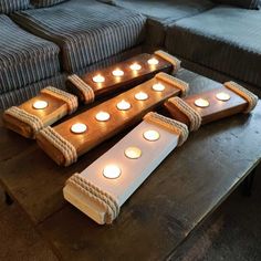 candles are arranged in the shape of boats on a coffee table next to a couch