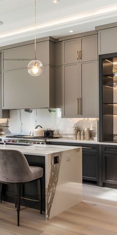 a modern kitchen with marble counter tops and gray cabinets