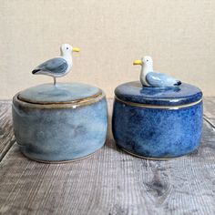 two ceramic containers with seagulls sitting on top