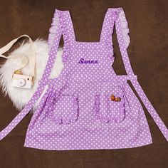 a purple polka dot apron with personalized name on it and a white fluffy bird