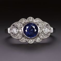 an antique sapphire and diamond ring, with three diamonds around it's center stone