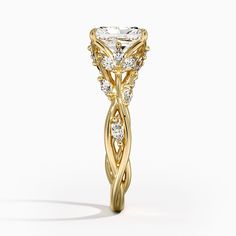 a yellow gold engagement ring with an intricate design on the side and round brilliant cut diamonds in the center