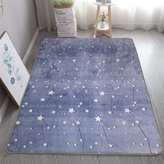 a blue rug with stars on it in front of a window and a plant next to it