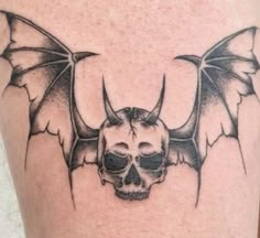 a skull and bat tattoo on the leg