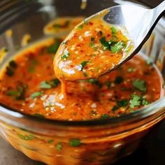 a spoon full of sauce and garnished with cilantro