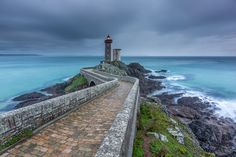 a lighthouse on top of a cliff near the ocean