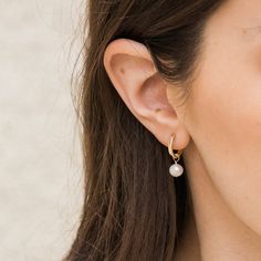 The Pearl Hoop Earrings are endlessly elegant, yet dainty enough to wear every day. A perfect pair of earrings to complete your look and take on your day! You can dress them up or down; whether it's a stroll in the sand or an evening in the city, these luscious hoops are sure to delight. DETAILS 14k gold filled -or- sterling silver 13mm wire & earrings Genuine 6mm freshwater pearls Two-in-one: you can remove the pearls to wear them as plain hoops Comes as a pair Safe for sensitive skin & shower Mini Pearl Earrings, Earings Minimalism, Pearl Earrings Outfit, Pearl Hoops Earrings, Dainty Pearl Earrings, Pearl Earrings Designs, Stacy London, Classic Pearl Earrings, Bridesmaid Gifts Earrings