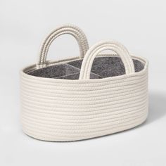 a white basket with two handles and rope