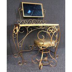 a gold desk with a mirror and stool in front of it on a gray carpeted floor