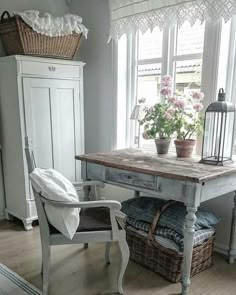 a chair and table in front of a window with flowers on the windowsills