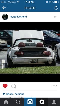 a white sports car parked next to other cars