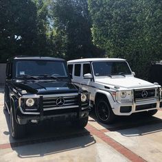 two mercedes benzs are parked next to each other