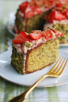 a piece of cake with strawberries on top is sitting on a plate next to a fork