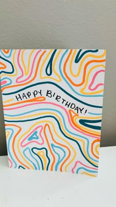 a card with the words happy birthday written in multi - colored swirls on it