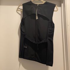 a women's black vest hanging on a hanger