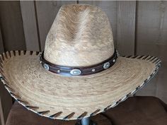 Brown leather has been trimmed with imprinted brown leather and accented with sunburst sliders and shiny nailspots. The hatband has brown leather lace and an antler bead that slides the hatband securely around the crown of your hat. It is 23" long and 20mm wide. Hat not included. Luxury Leather Hat Bands With Curved Brim, Custom Brown Hat Bands For Festival, Adjustable Brown Western Hat, Adjustable Distressed Brown Hats For Rodeo, Brown High Crown Country Hat, Adjustable Distressed Brown Country Hat, High Crown Brown Country Hat, Distressed Brown Adjustable Hat For Western-themed Events, Artisan Brown Hat Bands For Western-themed Events