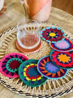 colorful crocheted coasters on wicker tray next to pitcher