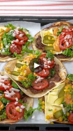 several tortillas with tomatoes, lettuce and other toppings on them