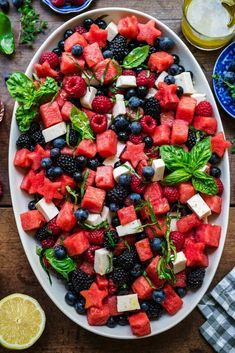 a watermelon salad with feta cheese, blueberries and raspberries