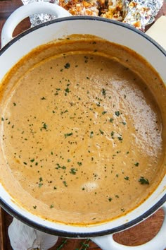 a bowl of soup sitting on top of a wooden table