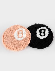 two crocheted coasters with the letter b on them, one in black and one in pink