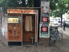 an old phone booth with graffiti on the walls and doors, next to a bicycle parked in front of it