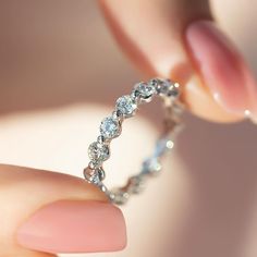 a woman's hand holding a diamond ring