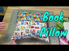 someone is making a book pillow out of fabric and paper with the word's name printed on it