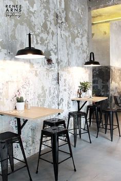 the interior of a restaurant with tables and chairs in front of a wall painted white