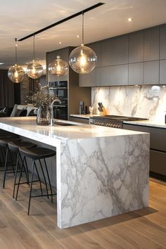 a kitchen with marble counter tops and bar stools next to an island in the middle